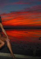 Длинноволосая красотка хвастается телом на причале 6 фотография