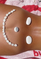 Нудистка выложила камешки рядом с загорелой писькой 6 фотография